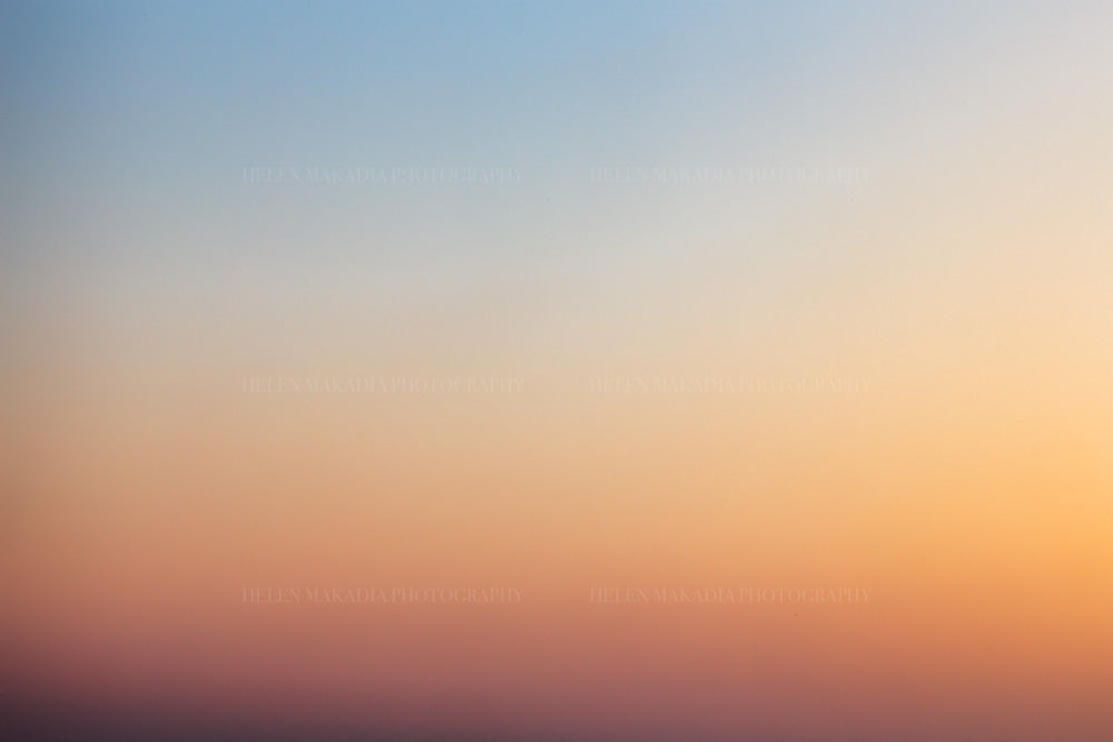 Photograph of a sunset gradient from peach pink to blue hues