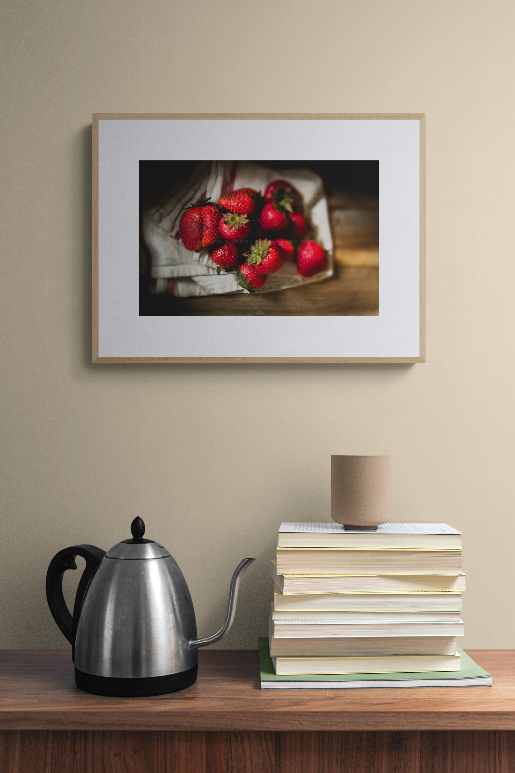 Framed photograph print of strawberries above a kitchen counter.