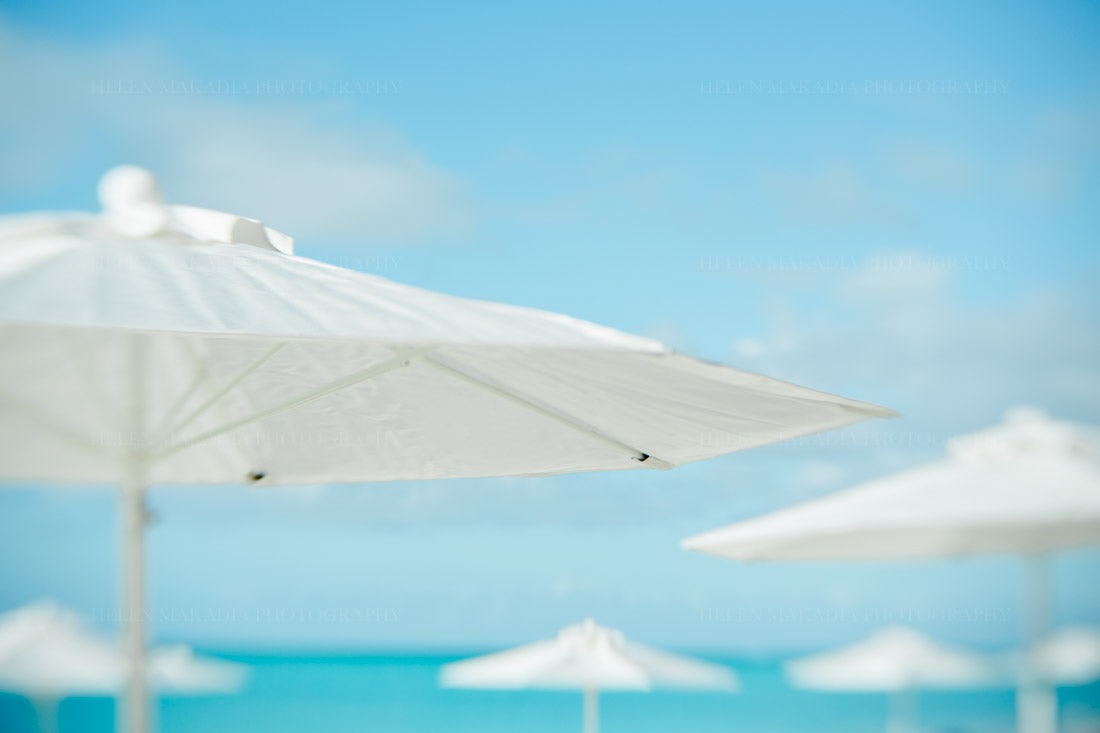 A photograph of white umbrellas on the beach in Grace Bay in Turks and Caicos.