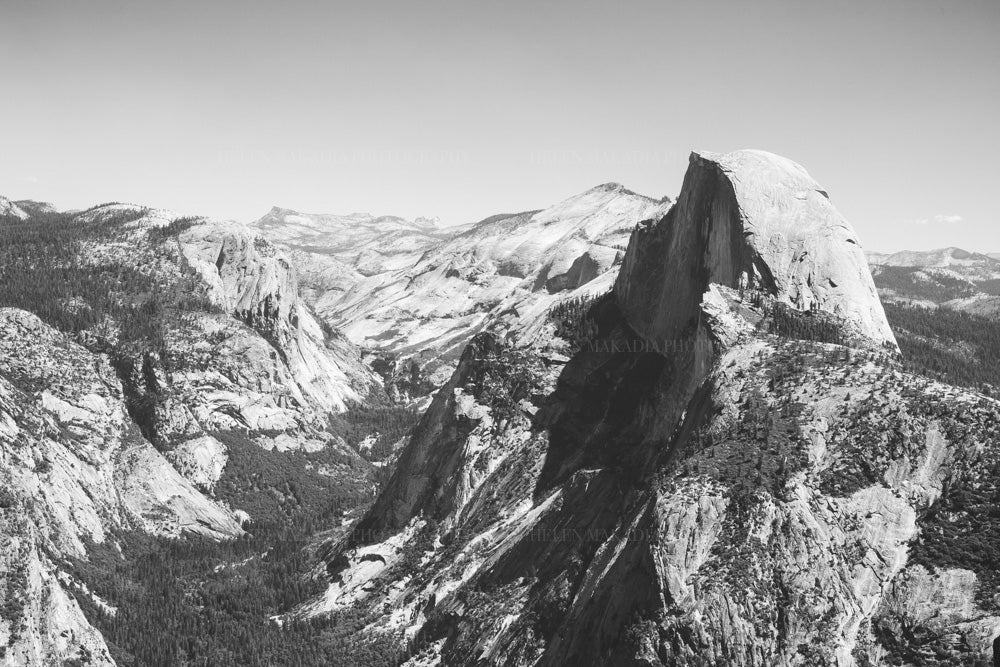 Black and white photograph of Yosemite's Half Dome andn landscape around it.  