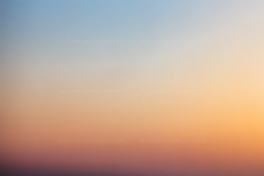 Photograph of a sunset gradient from peach pink to blue hues
 