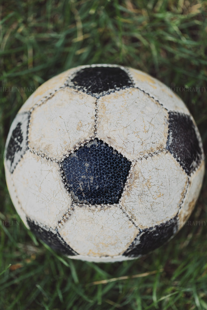 Photograph of a well-loved, worn and distressed soccer ball