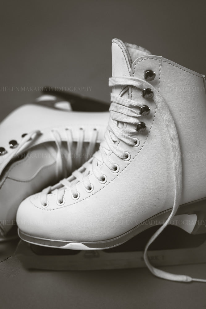 Black and white photograph of white figure skates with laces as wall art