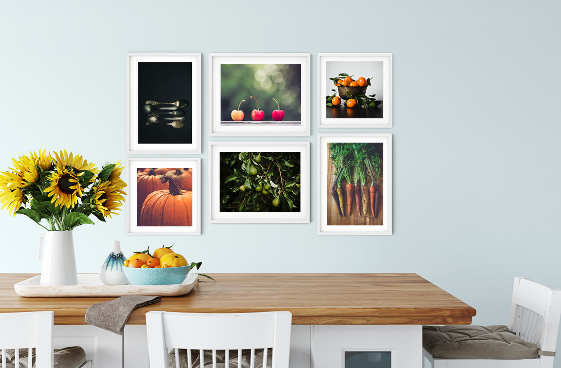 Photographs of Spoons, Pumpkins, Cherries, Oranges, and Pear Trees displayed as a Gallery Wall in a Kitchen as Wall Art