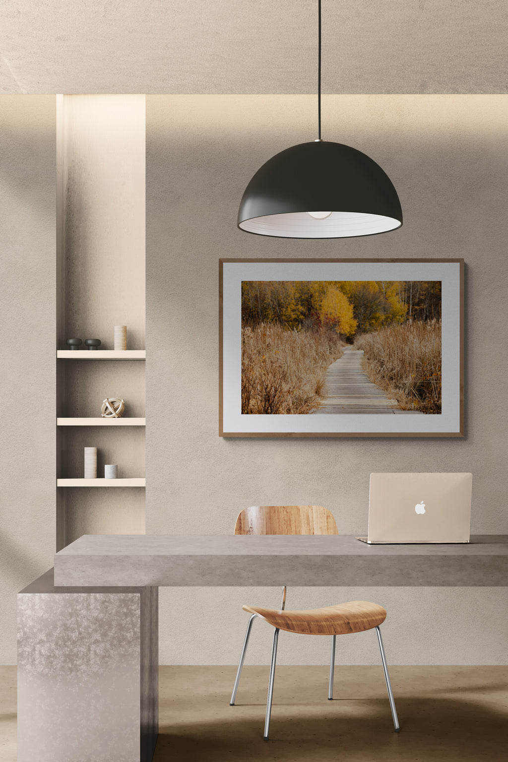 A framed nature photograph of a boardwalk and fall foliage in a modern office.