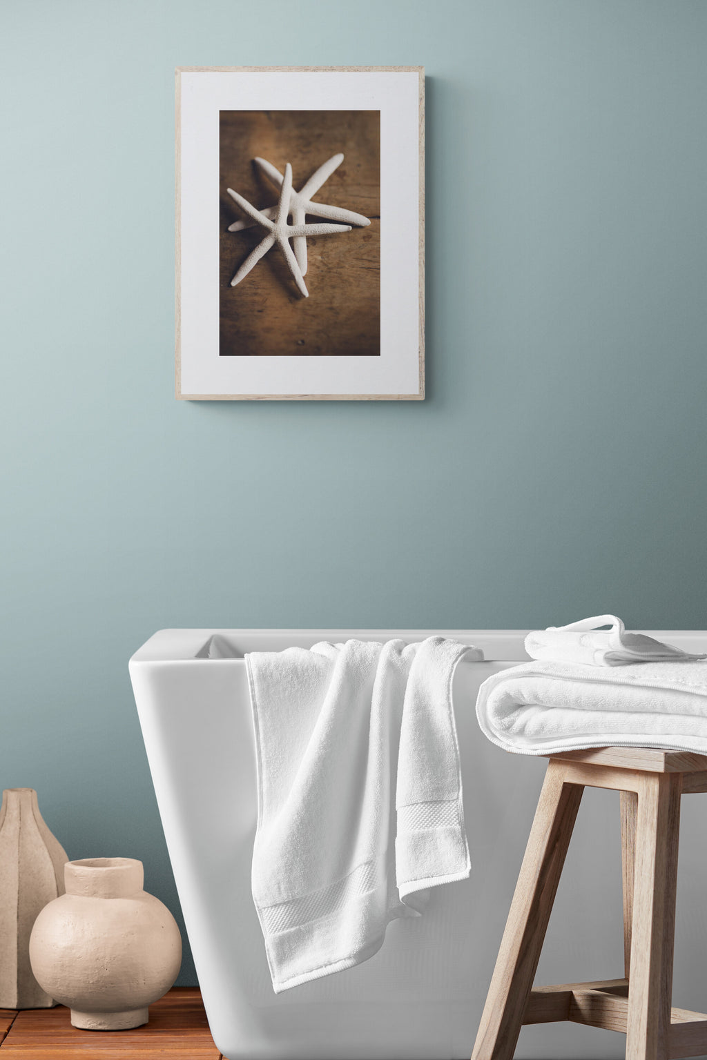 A photograph of white starfish photograph print in a bathroom as wall art.