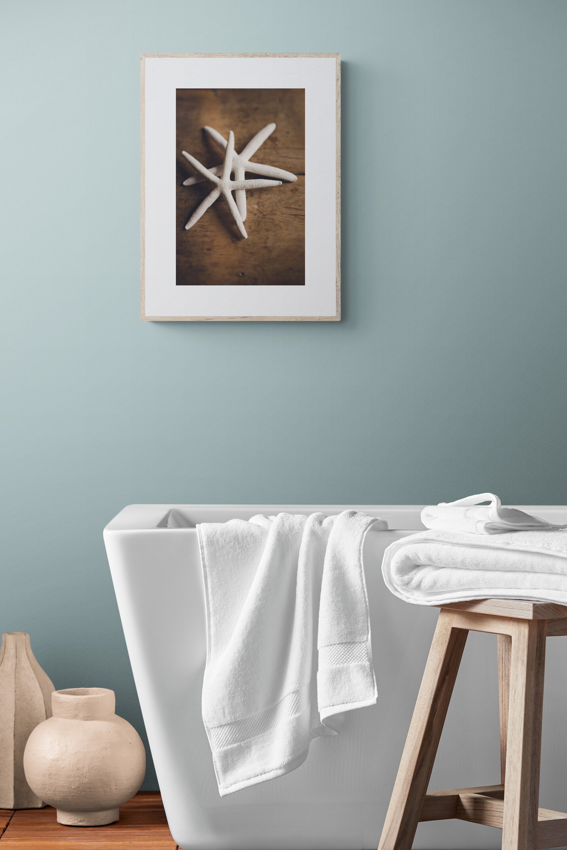 A photograph of white starfish photograph print in a bathroom as wall art.