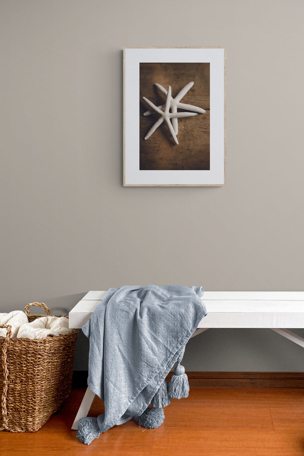 A photograph of white starfish photograph print in an entryway as wall art.