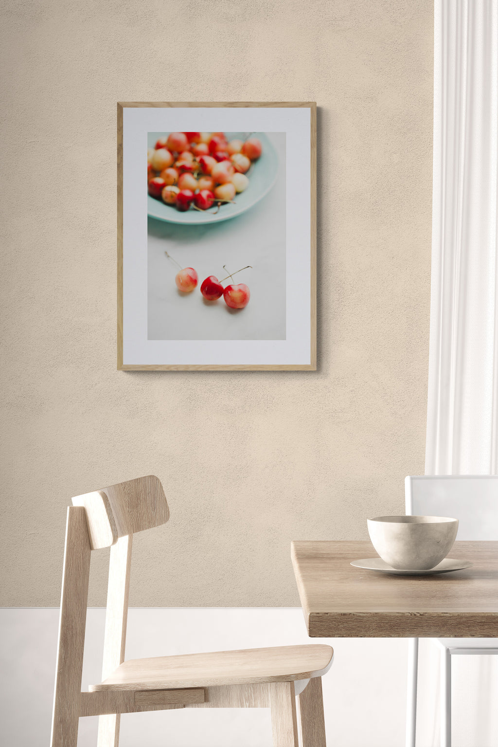 photograph of colorful rainier cherries on a blue platter as wall art in a dining room.