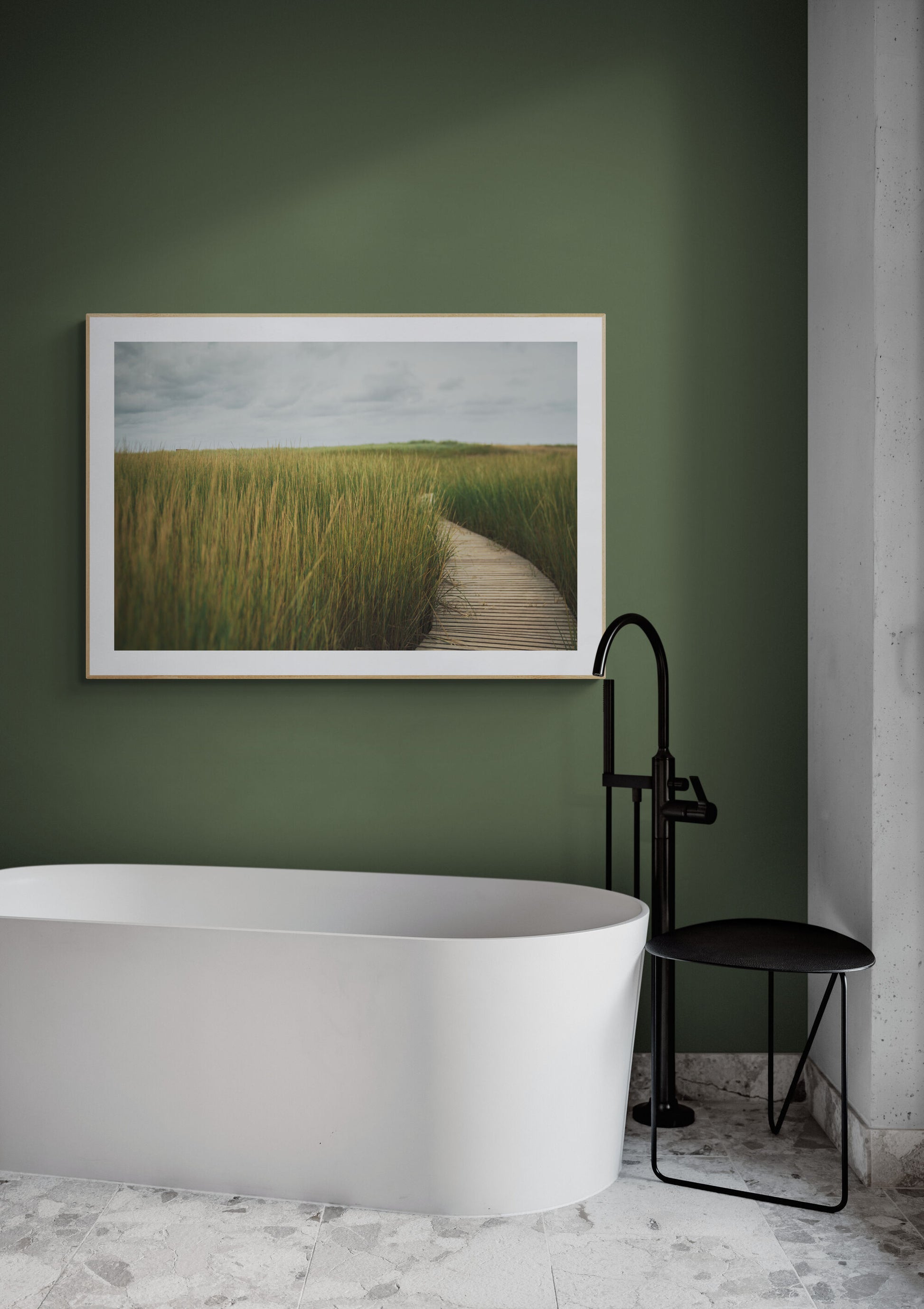 A photograph of a wooden boardwalk peeking through tall sea grass as wall art in a bathroom.