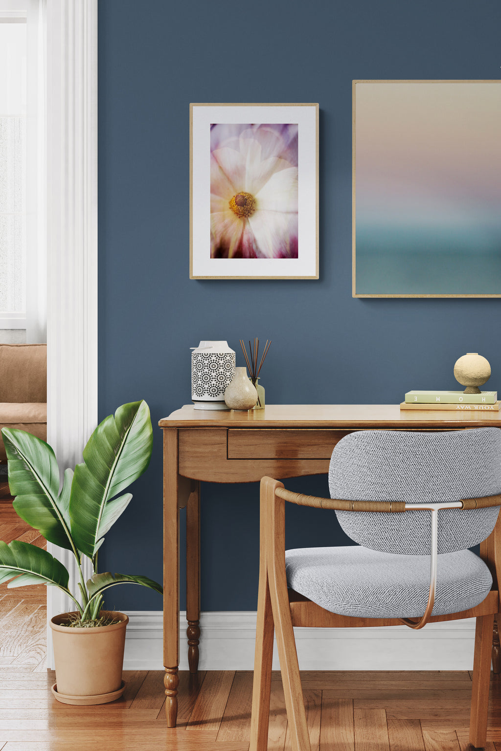 A painterly photograph of a pink ranunculus as wall art in a home office as aesthetic inspo.