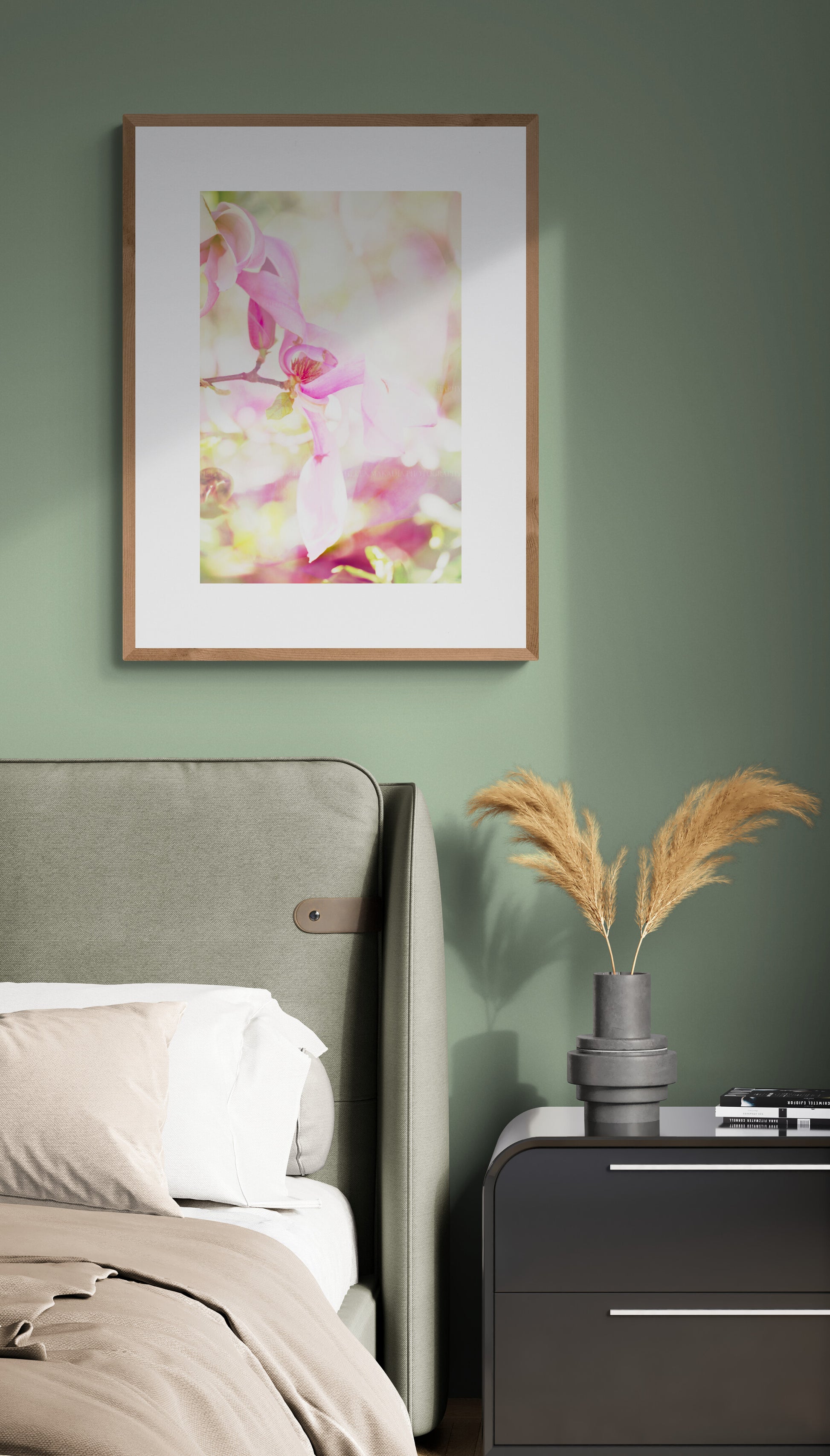 A framed photograph of pink magnolia as wall art in a bedroom