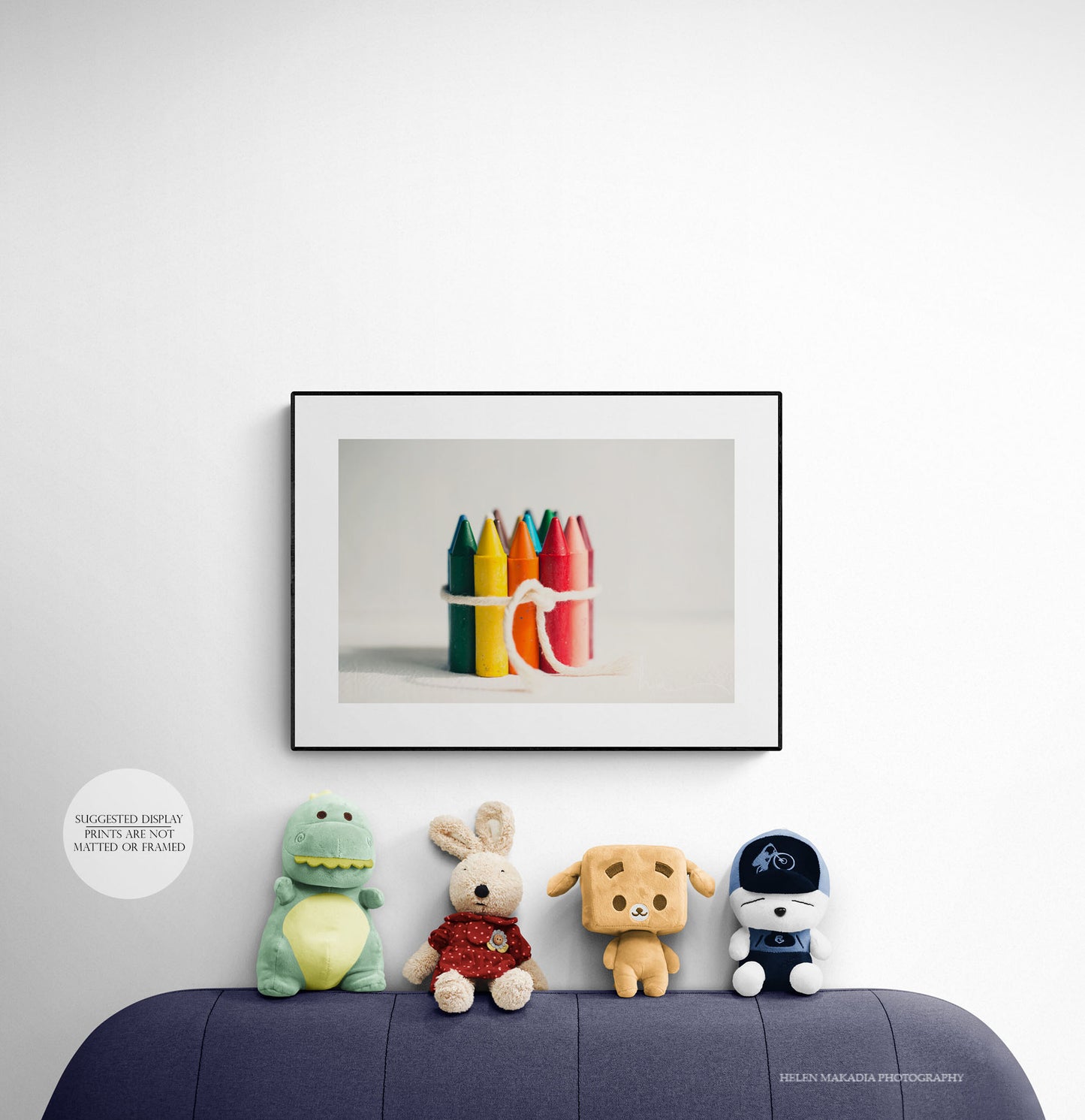 A framed photograph of a group of rainbow crayons, as wall art in a kid's room