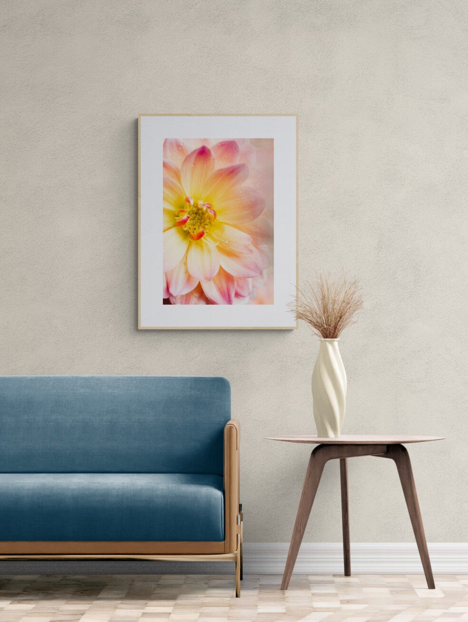 Pink and yellow dahlia photograph print displayed as wall art in a living room