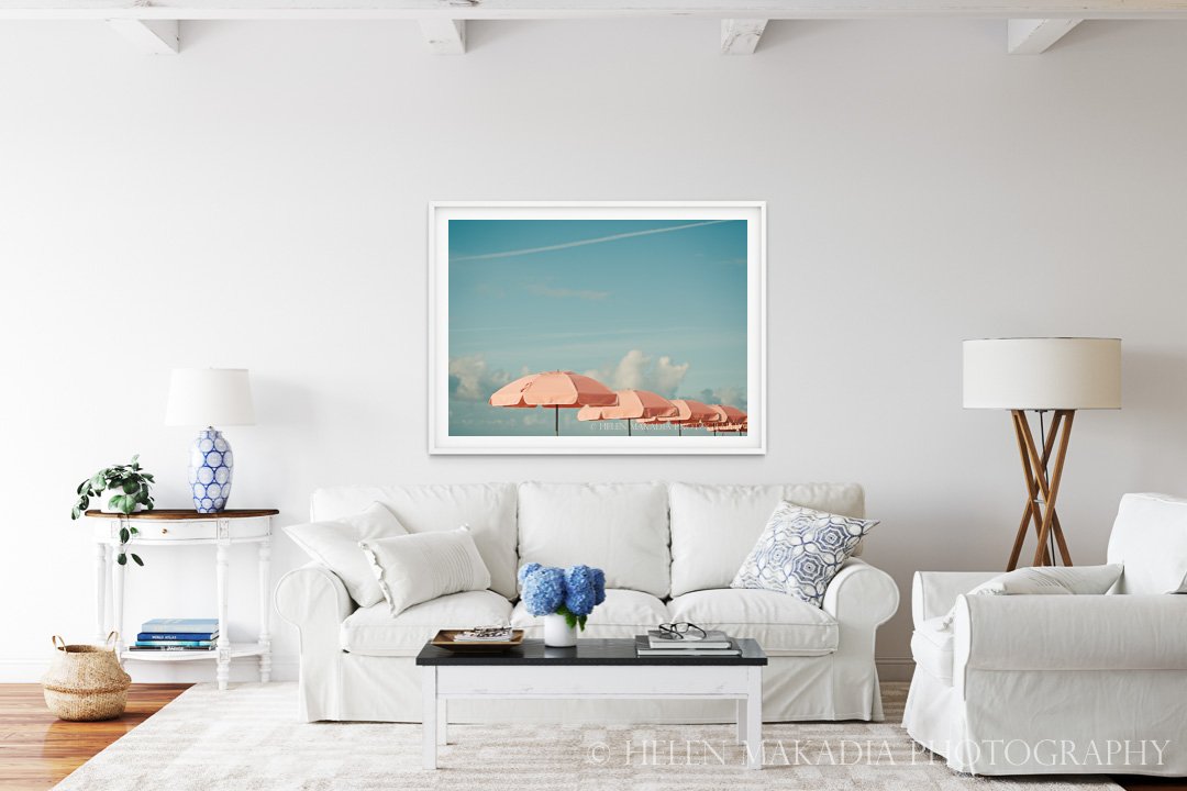 Coral Beach Umbrellas Photograph against a Blue Sky in a Living Room